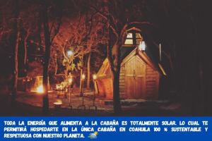 una pequeña cabaña de madera en el bosque por la noche en Pequeña cabaña mágica con chimenea interior, en Arteaga