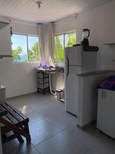 a kitchen with a refrigerator and a desk in it at Casa beira do mar in Florianópolis