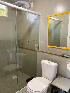 a bathroom with a toilet and a glass shower at Casa beira do mar in Florianópolis