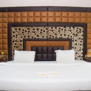 Una cama con dos almohadas encima. en Hotel Belisco, en Owerri