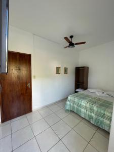 - une chambre avec un lit et un ventilateur de plafond dans l'établissement Practic Pousada, à Aparecida