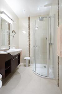 ein Bad mit einer Dusche und einem Waschbecken in der Unterkunft Pension Sprinzl in Schwechat