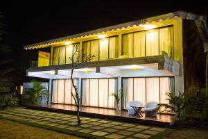 una casa con dos sillas delante de ella por la noche en Marbela Beach Resort, en Morjim