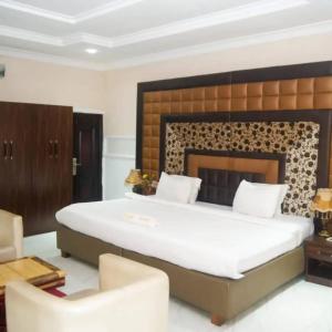 a bedroom with a large bed and a fireplace at Hotel Belisco in Owerri
