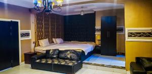 a bedroom with a bed and a couch in it at Hotel Belisco in Owerri