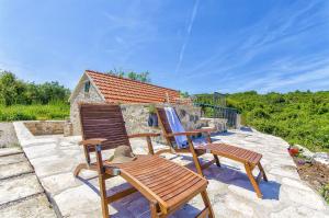 two chairs and a hat sitting on a patio at House Vinko in Račišće +20 photos