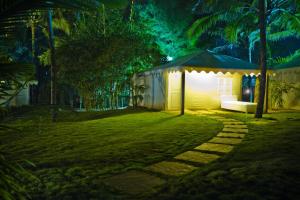 a tent in the middle of a yard at night at Marbela Beach Resort in Morjim