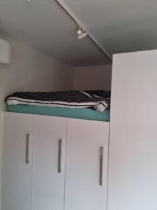 1 cama sobre armarios blancos en una habitación en Zwols stadshuis, en Zwolle