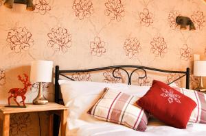 1 dormitorio con 1 cama con almohadas rojas y blancas en Cabana Stana Tarle en Sinaia