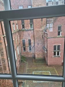 een uitzicht vanuit een raam van een bakstenen gebouw bij Zwols stadshuis in Zwolle