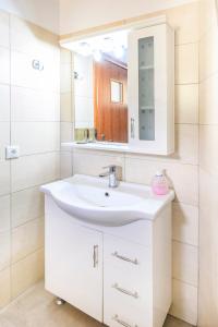 y baño con lavabo blanco y espejo. en Small Villa Gerani, en Agios Vlasios