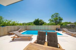 a backyard with a swimming pool and chairs and a fence at Apartments Fortis in Drage