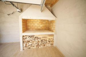 a room with a brick fireplace in the middle at Apartments Fortis in Drage