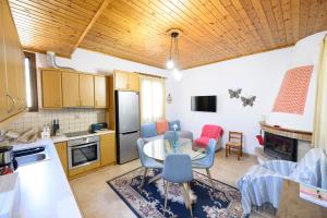a kitchen and living room with a table and chairs at Small Villa Gerani in Agios Vlasios +20 photos