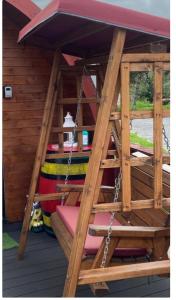 a wooden structure with a porch with a swing at Heatherbrae Cosy Wooden Pod in Kyle of Lochalsh