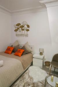 a bedroom with a bed with orange pillows on it at Appartement à côté Tour Eiffel in Paris