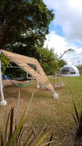 a building with a hammock and a tent in a field at Dome in the Heart of Boquete. in Boquete