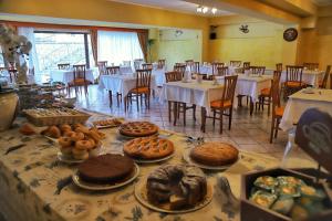 a dining room with tables and chairs with cakes and pastries at Hotel Tiffany's in Roccaraso