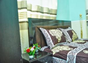 - un canapé avec des oreillers et des fleurs sur une table dans l'établissement CTD Global Integrated, à Jos