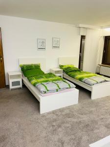 2 Betten in einem Zimmer mit grüner Bettwäsche in der Unterkunft Monteur Zimmer bis 16 Personen Preis verhandelbar in Linsengericht