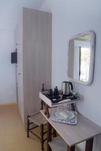 a bathroom with a table with a mirror and a sink at Marina Hotel in Agios Kirykos