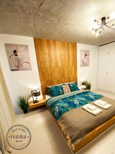 a bedroom with a large bed with a wooden headboard at habitat The River Apartment in Ruse
