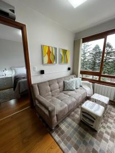 uma sala de estar com um sofá e uma cama em Flat Gramado Home Sweet Home em Gramado