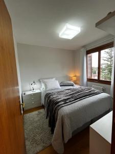 Un dormitorio con una cama grande y una ventana en Flat Gramado Home Sweet Home, en Gramado