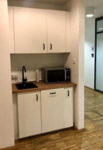 a kitchen with white cabinets and a microwave at Apartment Grindelallee Hamburg in Hamburg