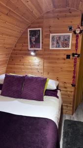 um quarto com uma cama numa parede de madeira em Heatherbrae Cosy Wooden Pod em Kyle of Lochalsh