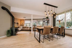 a dining room and living room with a table and chairs at Fantastic family home, garden and free parking in Aerdenhout