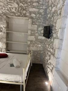 a bedroom with a bed in a stone wall at Maison Carolina in Vieste