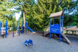 a playground with a slide and a play structure at Ocean Trails Resort in Parksville