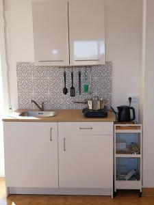 a kitchen with white cabinets and a sink at "Oliveiras" Appartement typique avec terrasse et piscine in Loulé