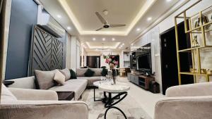 een woonkamer met een bank en een tafel bij LMY Elysium Designer Luxury Apartments Facing Centaurs Mall Islamabad in Islamabad