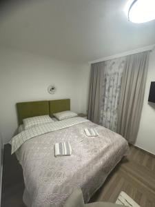 a bedroom with a bed with two pillows on it at Apartmani Emily & Jully in Nikšić