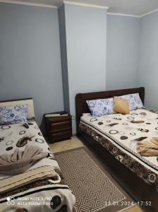 a bedroom with two beds and a night stand at Romana Hotel in Chişinău