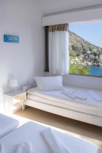 a bedroom with a bed with a window with a view at Marina Hotel in Agios Kirykos