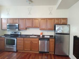 eine Küche mit Holzschränken und einem Kühlschrank aus Edelstahl in der Unterkunft comfy cozy roomy in Schenectady
