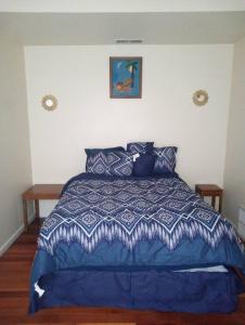 sypialnia z niebieskim łóżkiem z niebieską kołdrą w obiekcie comfy cozy roomy w mieście Schenectady