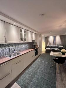 a kitchen with white cabinets and a living room at Spacious and Beautiful Apartment in Bergen with free parking in Bergen