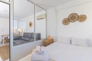 a white bedroom with a bed and a couch at Blonzu Taiwán in Torremolinos