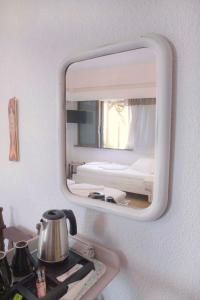 uno specchio appeso a un muro sopra un lavandino di Marina Hotel ad Agios Kirykos