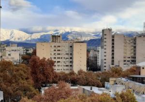 a city with snow covered mountains in the background at Habitaciónes en Departamento Céntrico in Mendoza