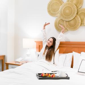 Hotel Melia Lima في ليما: امرأة في السرير وذراعيها في الهواء