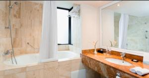 y baño con bañera y lavamanos. en Hotel Melia Lima, en Lima