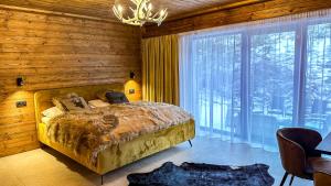 ein Schlafzimmer mit einem Bett und einem großen Fenster in der Unterkunft Jasna Boutique Chalet in Liptovský Mikuláš