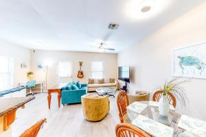 uma sala de estar com uma mesa e um sofá em Marlin Street C em South Padre Island