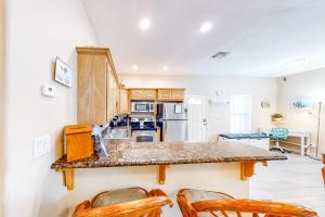 a kitchen with a counter and chairs in a room at Marlin Street C in South Padre Island