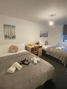 Camera con 2 letti, asciugamani e scrivania. di Lovely Triple and Quadruple Bedrooms in Euston a Londra